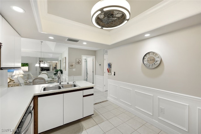 kitchen with white cabinets, a raised ceiling, sink, hanging light fixtures, and a chandelier