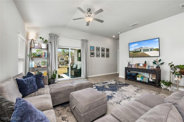 living room featuring ceiling fan, hardwood / wood-style floors, and vaulted ceiling