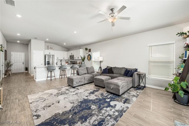 living room with ceiling fan and lofted ceiling