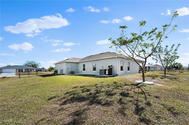 rear view of house featuring a lawn and cooling unit