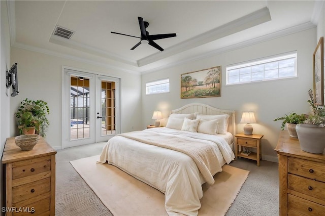 carpeted bedroom featuring access to exterior, french doors, ornamental molding, a tray ceiling, and ceiling fan