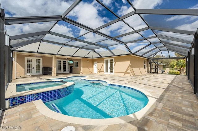 view of pool featuring glass enclosure, a patio area, an in ground hot tub, and french doors