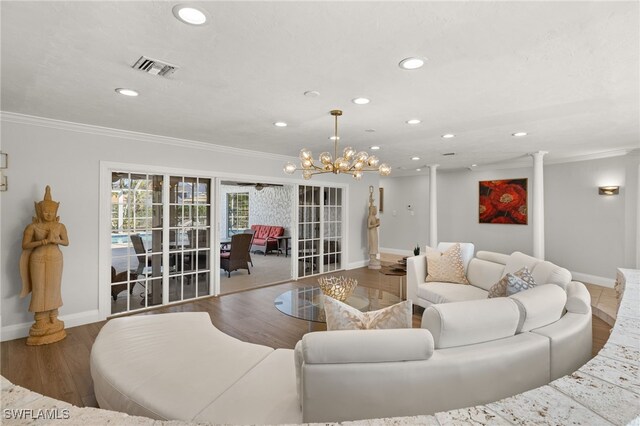 living room with hardwood / wood-style flooring, ornamental molding, and decorative columns