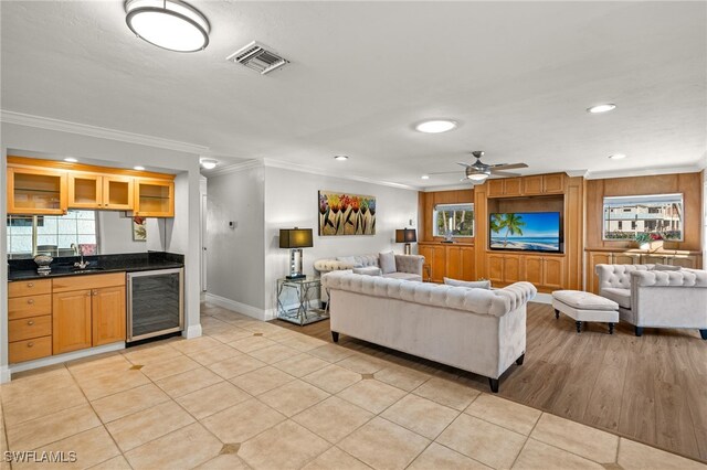 living room with light tile patterned floors, crown molding, beverage cooler, and indoor wet bar