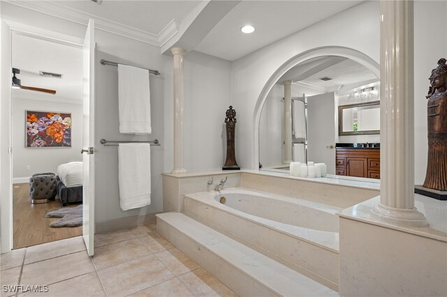 bathroom with ornate columns, ornamental molding, vanity, tiled tub, and tile patterned flooring