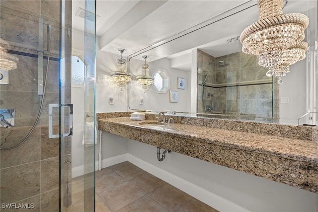 bathroom with an enclosed shower, sink, and tile patterned floors