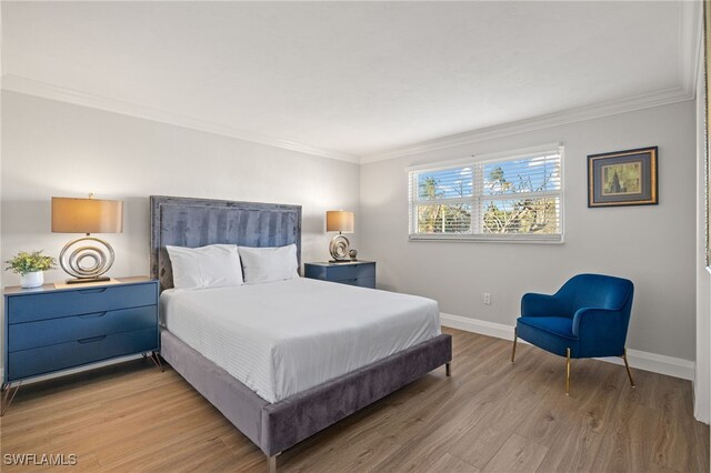 bedroom with ornamental molding and light hardwood / wood-style flooring