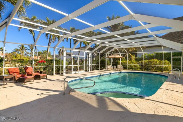 view of swimming pool featuring a patio, outdoor lounge area, glass enclosure, and a hot tub