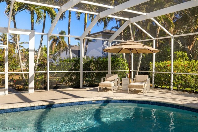 view of swimming pool featuring a patio and a lanai