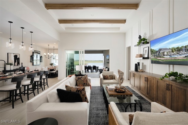 living room with an inviting chandelier, a towering ceiling, and beam ceiling