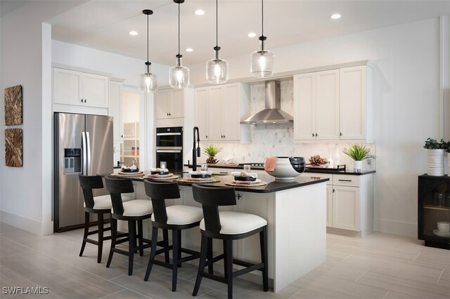 kitchen with wall chimney range hood, double oven, white cabinets, a center island with sink, and stainless steel fridge with ice dispenser