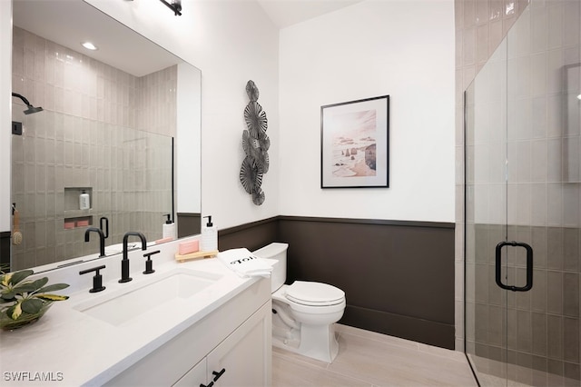 full bathroom with toilet, vanity, and a shower stall