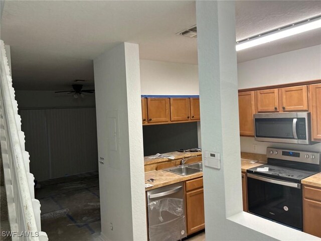 kitchen featuring ceiling fan, sink, and stainless steel appliances