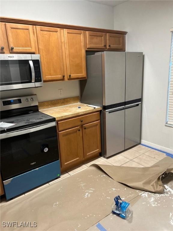 kitchen with appliances with stainless steel finishes and light tile patterned floors