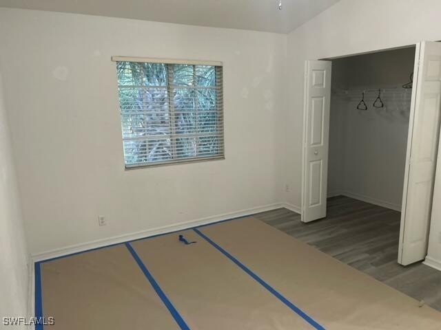 unfurnished bedroom with a closet and dark hardwood / wood-style floors