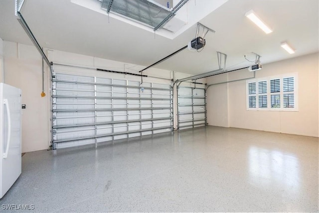 garage featuring white fridge and a garage door opener