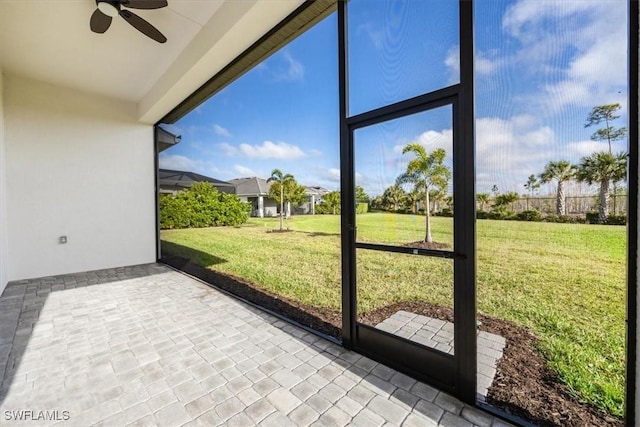 unfurnished sunroom featuring ceiling fan