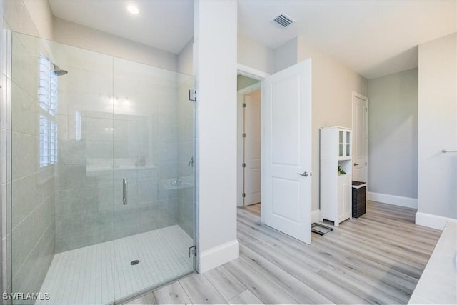 bathroom featuring wood-type flooring and walk in shower