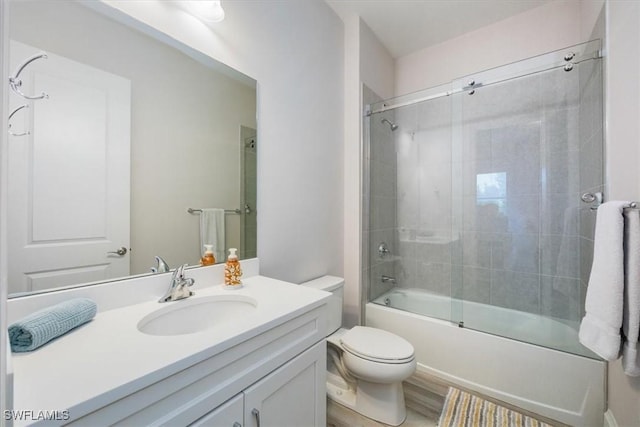 full bathroom featuring hardwood / wood-style flooring, vanity, enclosed tub / shower combo, and toilet