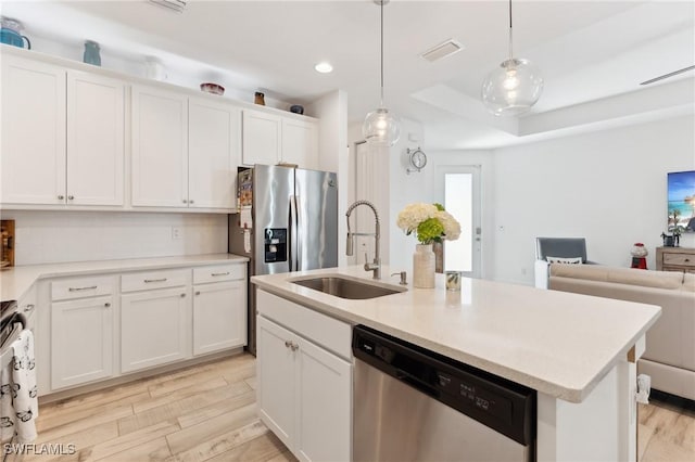 kitchen with sink, white cabinetry, hanging light fixtures, an island with sink, and stainless steel appliances