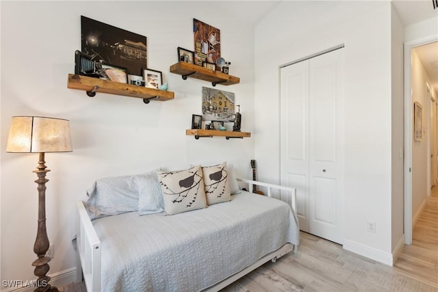 bedroom with light hardwood / wood-style flooring and a closet