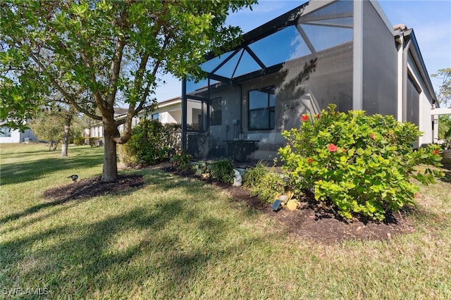 view of side of property with glass enclosure and a lawn