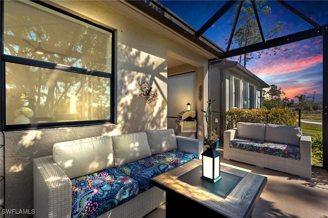 patio terrace at dusk with outdoor lounge area and a lanai