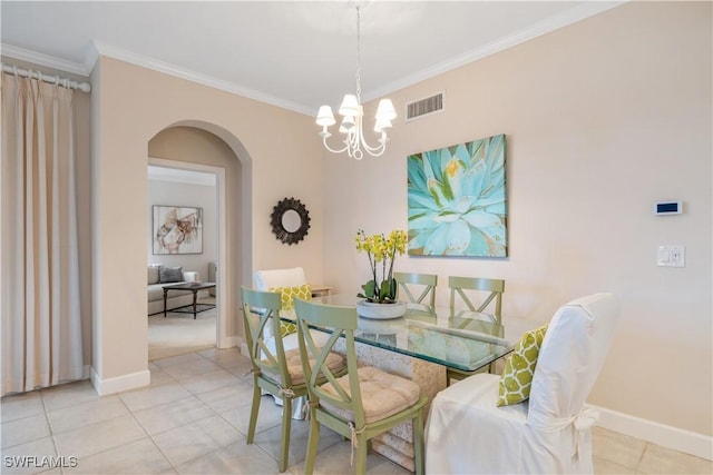 tiled dining space featuring crown molding and an inviting chandelier