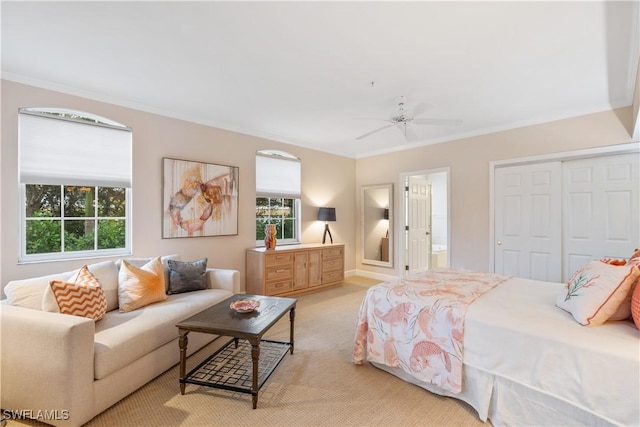 bedroom featuring ensuite bath, ceiling fan, crown molding, light carpet, and a closet