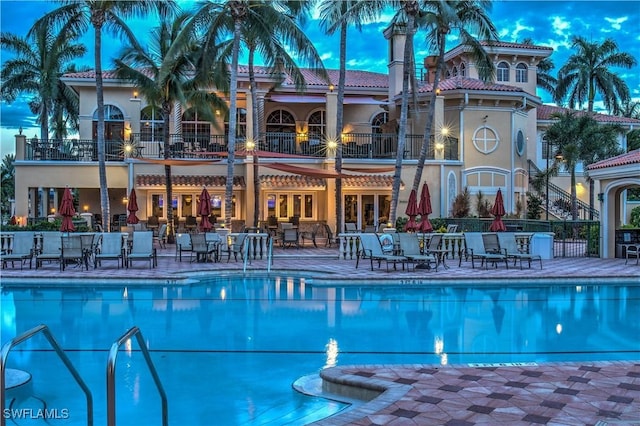 pool at dusk with a patio area