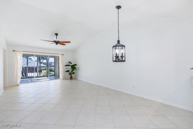 empty room with vaulted ceiling, ceiling fan with notable chandelier, and baseboards