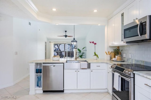 kitchen featuring a peninsula, white cabinetry, appliances with stainless steel finishes, and backsplash