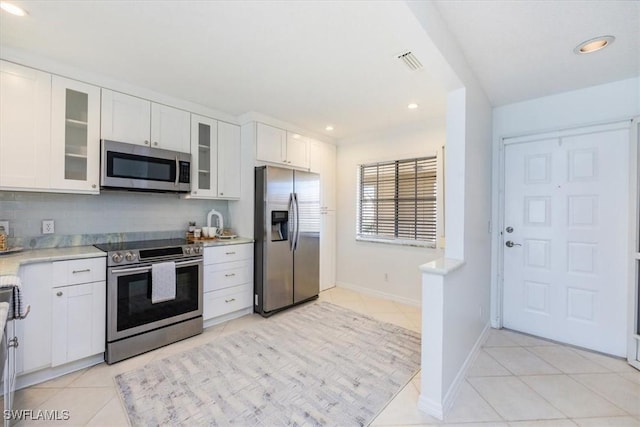 kitchen with light tile patterned floors, visible vents, stainless steel appliances, and light countertops