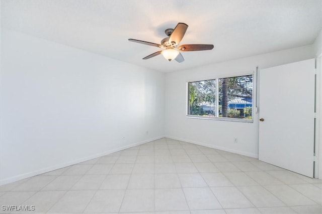 spare room with a ceiling fan and baseboards