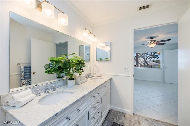 full bathroom featuring double vanity, visible vents, ornamental molding, a ceiling fan, and a sink