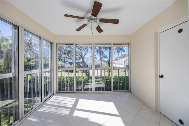 unfurnished sunroom with a ceiling fan