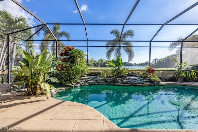 view of pool with glass enclosure and a patio