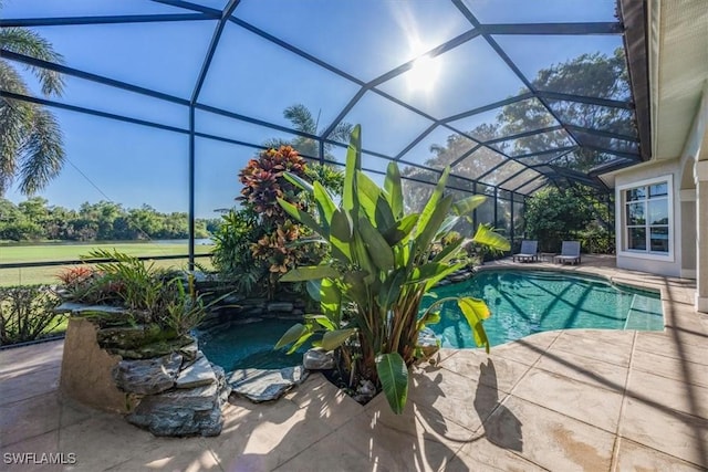 view of swimming pool with glass enclosure and a patio