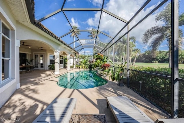 view of pool with french doors, a patio area, ceiling fan, and a lanai