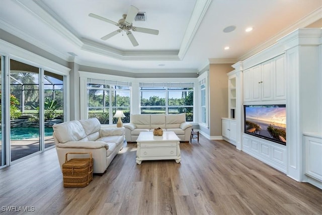 living room with a healthy amount of sunlight, ceiling fan, light hardwood / wood-style floors, and ornamental molding