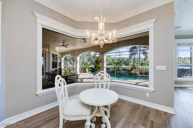 dining room with ornamental molding, ceiling fan with notable chandelier, and hardwood / wood-style flooring