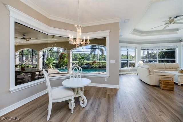 dining room with crown molding, wood-type flooring, and ceiling fan with notable chandelier