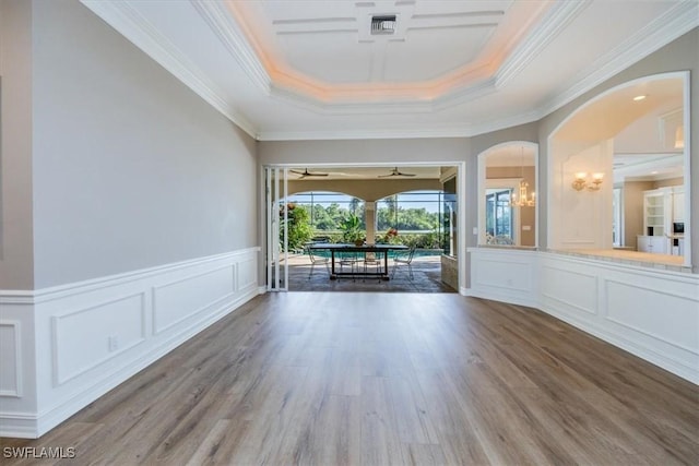 spare room with a raised ceiling, crown molding, and dark hardwood / wood-style floors