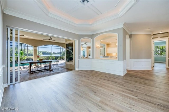 interior space with a raised ceiling, crown molding, ceiling fan, and light hardwood / wood-style floors