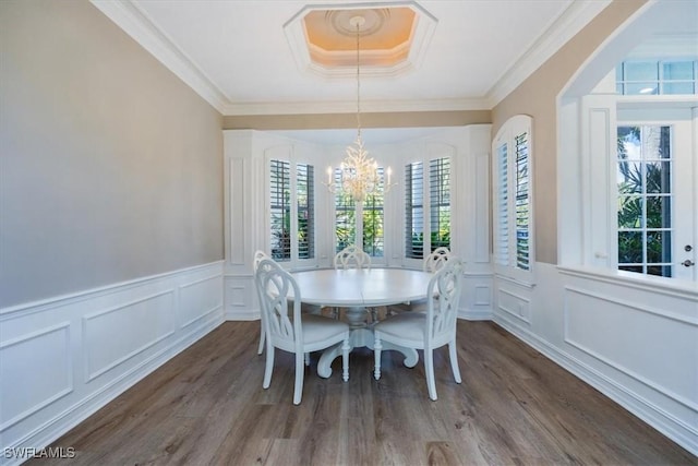 dining area featuring dark hardwood / wood-style flooring, an inviting chandelier, and ornamental molding