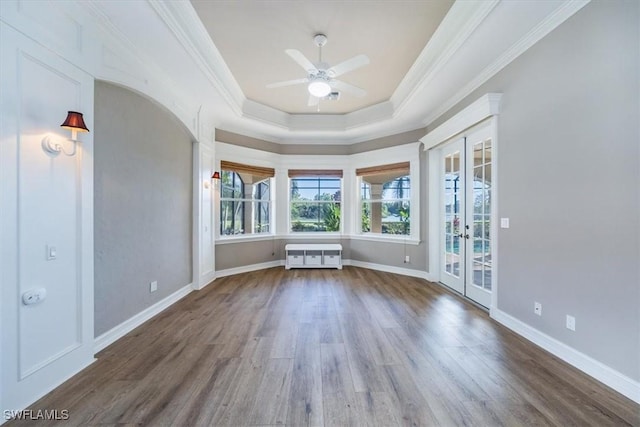 unfurnished room with french doors, crown molding, ceiling fan, and dark wood-type flooring