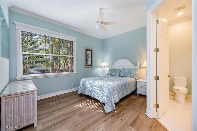 bedroom featuring hardwood / wood-style flooring, ceiling fan, ensuite bathroom, and crown molding