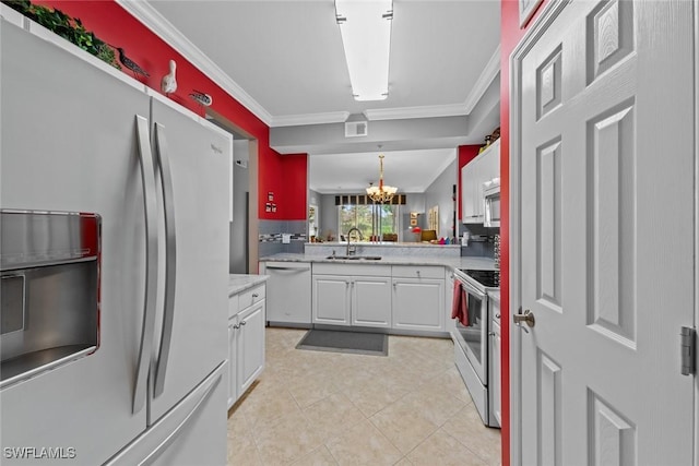 kitchen with stainless steel appliances, crown molding, sink, an inviting chandelier, and white cabinets