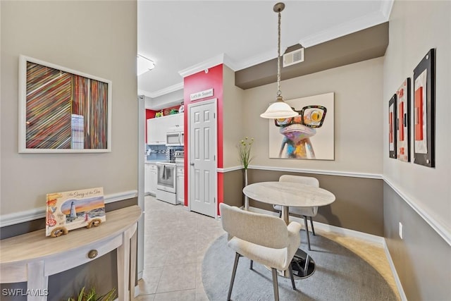 dining room with light tile patterned floors and ornamental molding