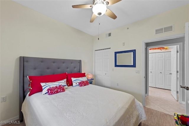 tiled bedroom with ceiling fan and a closet